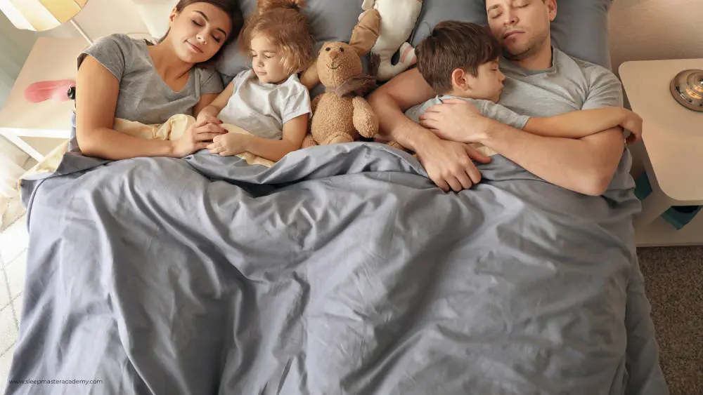 Prävention von Schlafproblemen - Eltern glücklichen mit KIndern im Bett