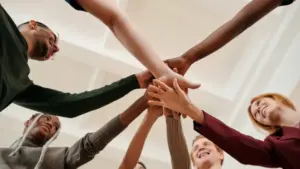 Sleepmaster Community - Junge Menschen legen ihre Hände sternförmig übereinander